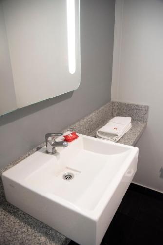 a white sink in a bathroom with a mirror at ibis Pilar in Pilar