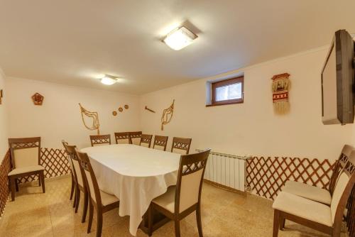 a dining room with a white table and chairs at Комплекс Орлово гнездо in Beli Iskar