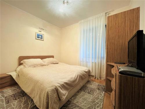 a bedroom with a bed and a flat screen tv at Комплекс Орлово гнездо in Beli Iskar