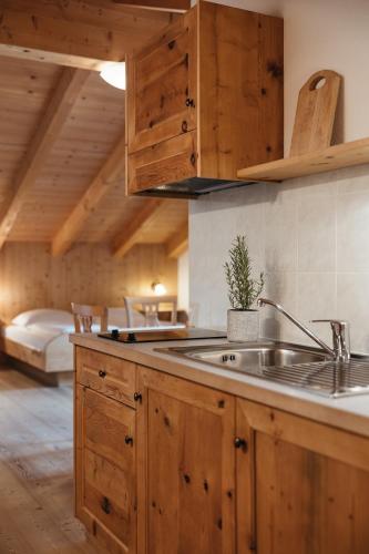 a kitchen with wooden cabinets and a sink at Garni Ciasa Urban in Badia