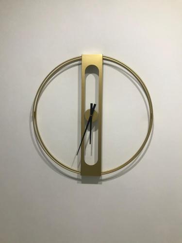 a clock is hanging on a white wall at Mica Apartments in Sere Kunda