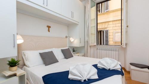 a bedroom with a large white bed and a window at Vittoria Rental in Rome in Rome