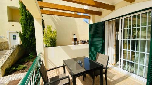 un patio con tavolo e sedie sul balcone. di Oliveira by Check-in Portugal a Vilamoura