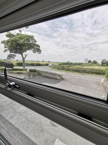 a window with a view of a road and a tree at The Shoulder at Hardstoft in Hardstoft