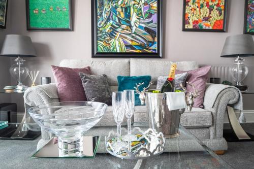 a living room with a couch and a table with wine glasses at Highcliffe House in Lynton