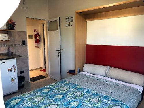 1 dormitorio con 1 cama y pared roja y blanca en DEPARTAMENTO ACOSTA 1 en Paraná