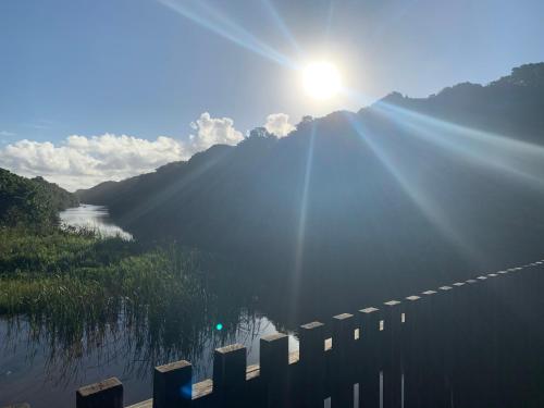 a sun shining over a body of water at Mtunzini Forest Lodge Self Catering Resort in Mtunzini