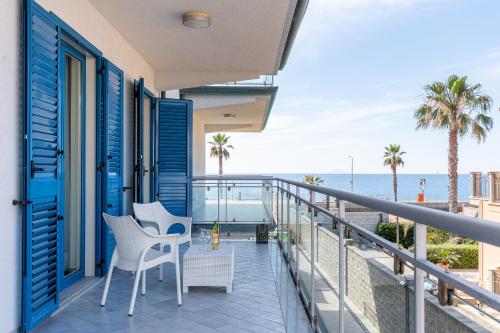 a balcony with chairs and a view of the ocean at Terraces d'Orlando - Family Apartments with Sea View and Pool in Capo dʼOrlando