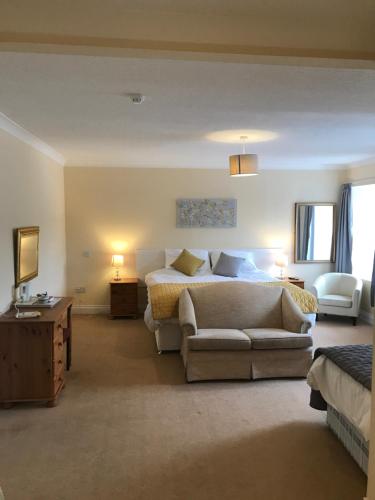 a large bedroom with a bed and a couch at The Maxwell Arms Hotel in Dalbeattie
