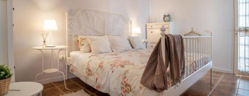 a white bedroom with a bed with a white headboard at DELUXE VILLA BELLA VITA AIR CON & HEATED POOL, Tenerife South in Chayofa