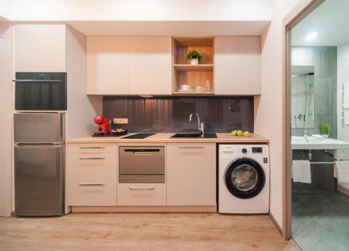 a kitchen with a washing machine and a washer at City Park Apart Hotel by CHM in Kyiv