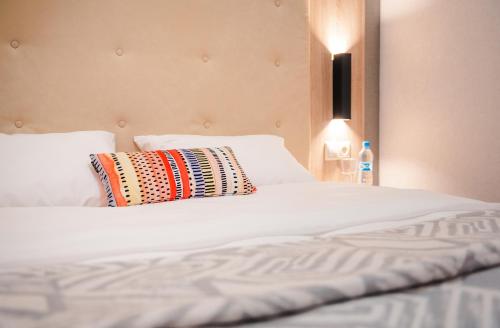 a white bed with a pillow on top of it at City Park Apart Hotel by CHM in Kyiv
