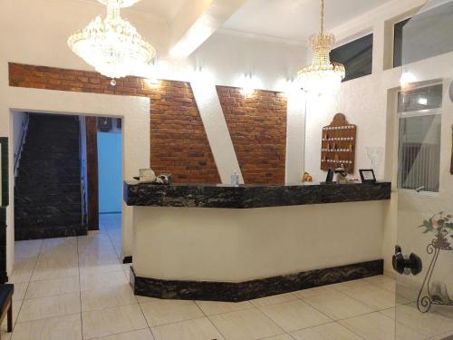 a lobby with a counter and chandeliers at Hotel Gabriel in Santa Maria