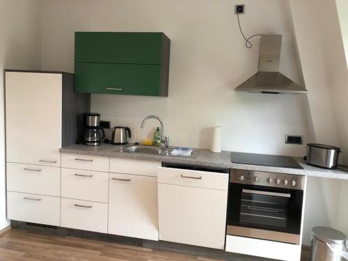uma cozinha com armários brancos e um armário verde em Wohnung im Zentrum des Ruhrgebietes 1A 3.OG em Castrop-Rauxel