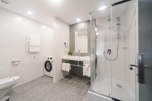 een badkamer met een douche, een wastafel en een toilet bij City Park Apart Hotel by CHM in Kiev