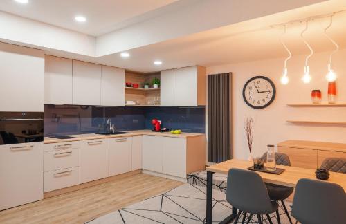 a kitchen with a table and a clock on the wall at City Park Apart Hotel by CHM in Kyiv