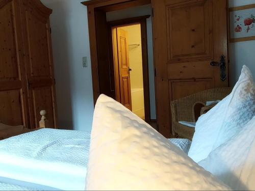 a bed with white sheets and pillows in a bedroom at Gästehaus Maier in Kitzbühel