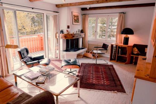 ein Wohnzimmer mit einem Couchtisch und einem Kamin in der Unterkunft Casa Nonna in Lenzerheide