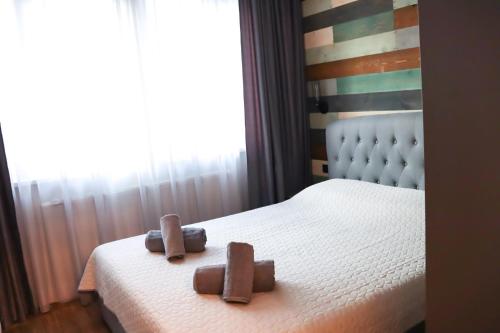 a bedroom with a bed with two wooden objects on it at Tsarevets Apartament-Veliko Tarnovo in Veliko Tŭrnovo