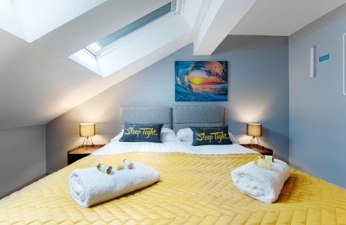 a bedroom with a large bed with towels on it at The Eistedfod Penthouse - Berwyn House in Wrexham
