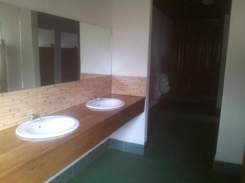 Un baño con dos lavabos y un espejo grande. en Panorama Safari Camp, en Mto wa Mbu