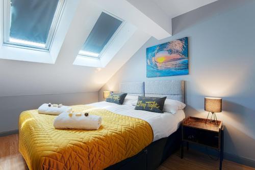 Schlafzimmer mit einem Bett mit gelber Bettwäsche und Fenstern in der Unterkunft The Eistedfod Penthouse - Berwyn House in Wrexham
