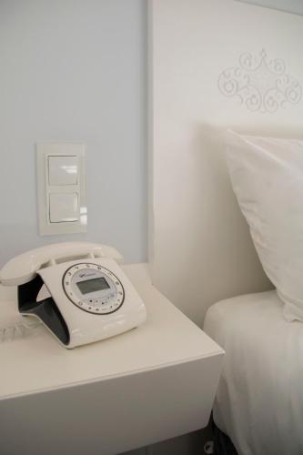 a white phone sitting on a table next to a bed at Hotel Alda San Bieito in Santiago de Compostela