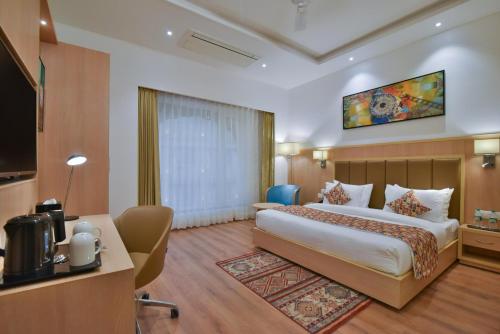 a hotel room with a bed and a flat screen tv at SureStay Heritage Walk By Best Western in Amritsar