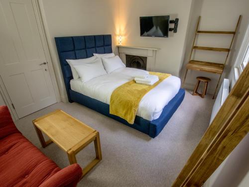 a small bedroom with a bed with a blue headboard at Regency House in Cambridge