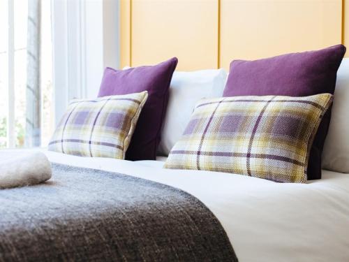 a bed with four pillows on top of it at Regency House in Cambridge