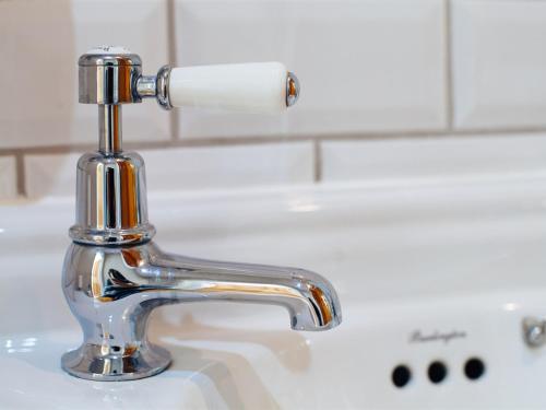 a chrome bathroom sink faucet with a roll of toilet paper at Regency House in Cambridge