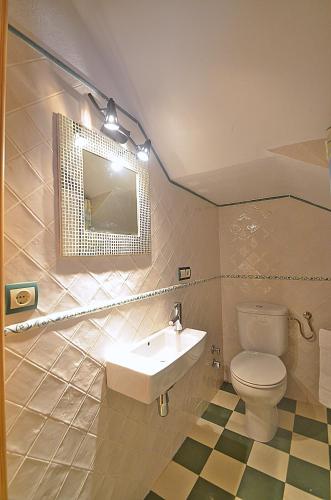 a bathroom with a sink and a toilet and a mirror at Casa Siesta in Granada