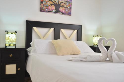 a bed with two swans towels on top of it at Casa Siesta in Granada