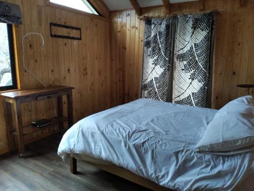 a bedroom with a bed and a table in a room at Refugio Altazor in Las Trancas