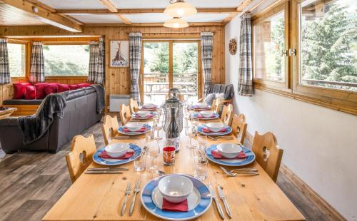 une salle à manger avec une longue table en bois et des chaises dans l'établissement Chalet Himalaya , 10 Person Chalet with 5 ensuite bedrooms and outdoor jacuzzi in Meribel Centre, à Méribel
