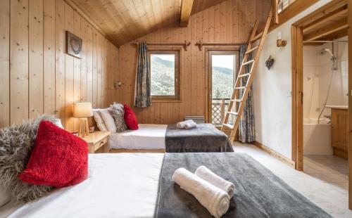 a room with two beds and a ladder and a bathroom at Chalet Himalaya , 10 Person Chalet with 5 ensuite bedrooms and outdoor jacuzzi in Meribel Centre in Méribel