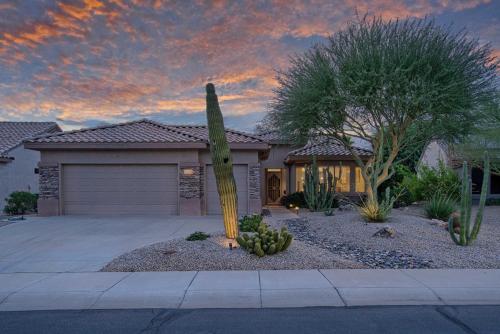 a cactus in front of a house with a garage at Pool and Spa Home on Golf Course in Surprise! in Surprise
