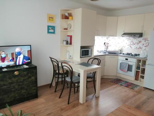 a kitchen with a table and chairs and a television at Slávik Apartment in Dunajská Streda
