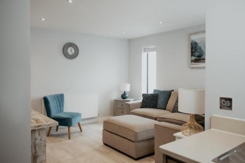 a living room with a couch and a chair at 2 The Mews, Upper Bath Street in Cheltenham