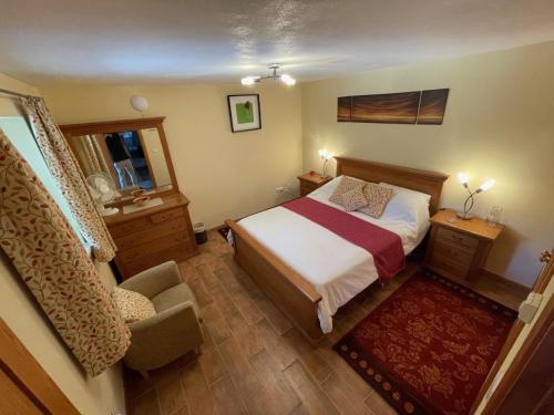 a bedroom with a bed and a chair and a mirror at Casa Azul self-catering apartment with gorgeous biological swimming pool in Avelar