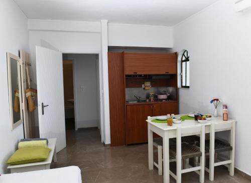 Phaistos Hotel في تولو: مطبخ به طاولة بيضاء ومطبخ صغير
