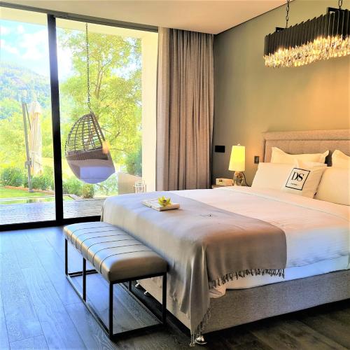 a bedroom with a large bed and a large window at Douro Suites in Riba Douro