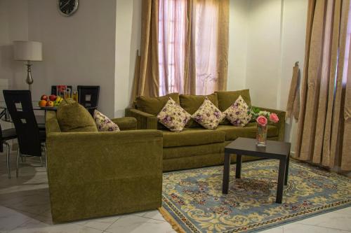 a living room with a green couch and a table at ماجيك سويت بلس Magic Suite PLus in Kuwait