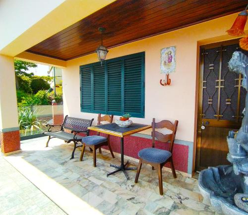 a patio with a table and chairs and a house at Casa da Maria 15 - Funchal - Famílias in Funchal