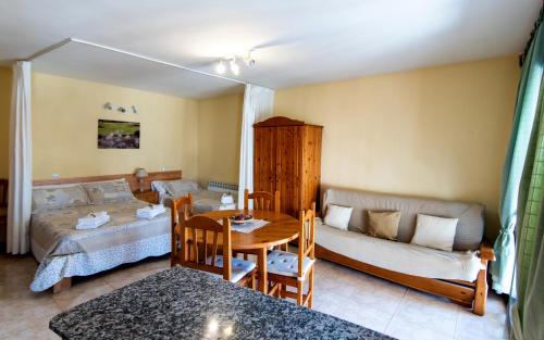 a living room with a bed and a table at Apartamentos Maribel in Calaceite
