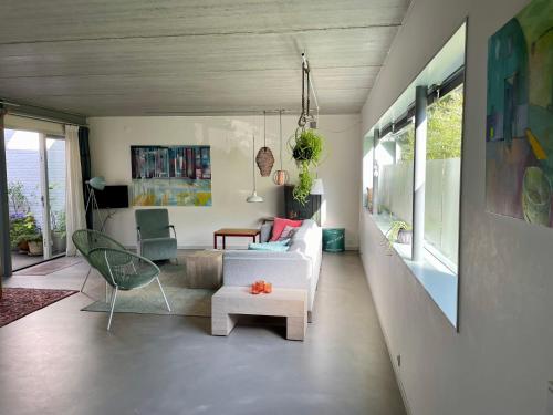 a living room with a white couch and a chair at Studio In de Hoet in Nijmegen