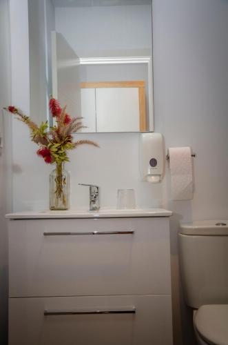 a bathroom with a sink and a vase with flowers at Hostal Restaurante Benalup Golf in Benalup Casas Viejas