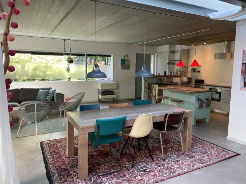 een keuken en een woonkamer met een houten tafel en stoelen bij Studio In de Hoet in Nijmegen