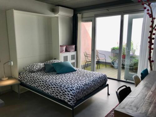 een slaapkamer met een bed en een balkon bij Studio In de Hoet in Nijmegen
