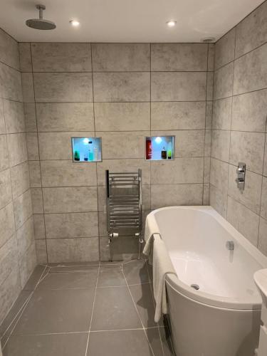 un baño con bañera y lavabo en Chestnut-Lodge is rural, secluded, private with Hot Tub, en Maidstone